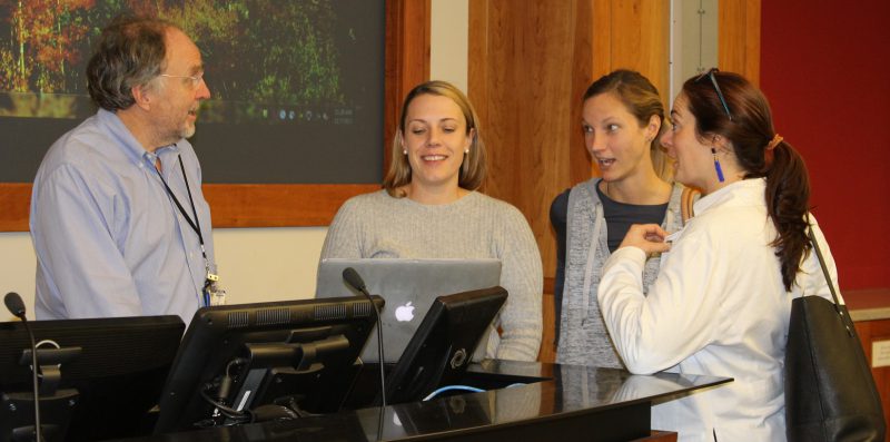 Professor Carl Pieper discusses longitudinal data after class with three students. 