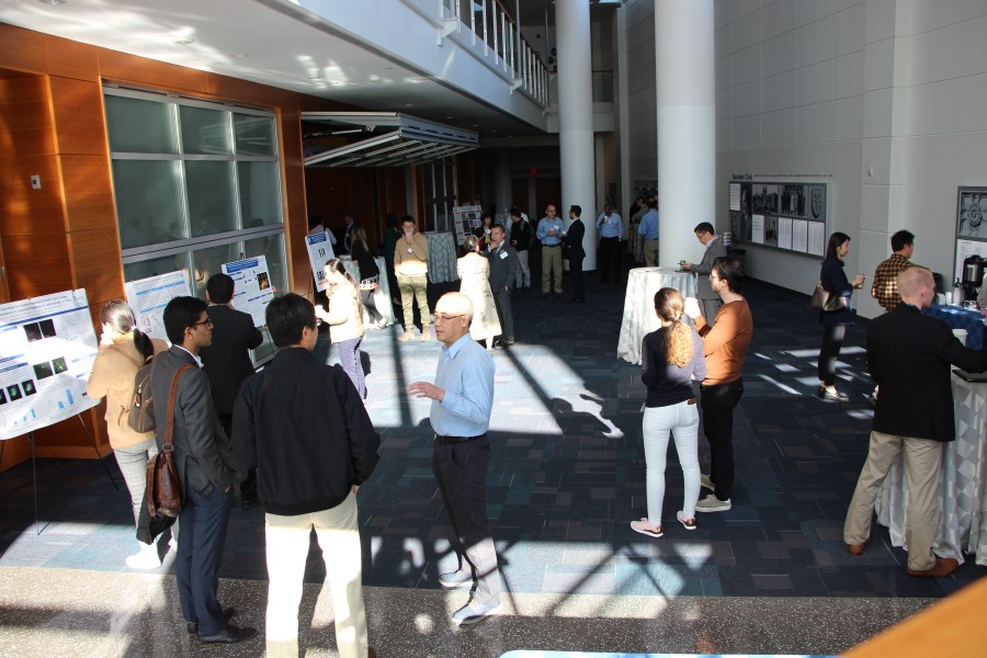 The crowd chats and explores the posters during a break at the DAP symposium.