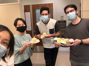 four lab students kick off new collaboration by sharing cake
