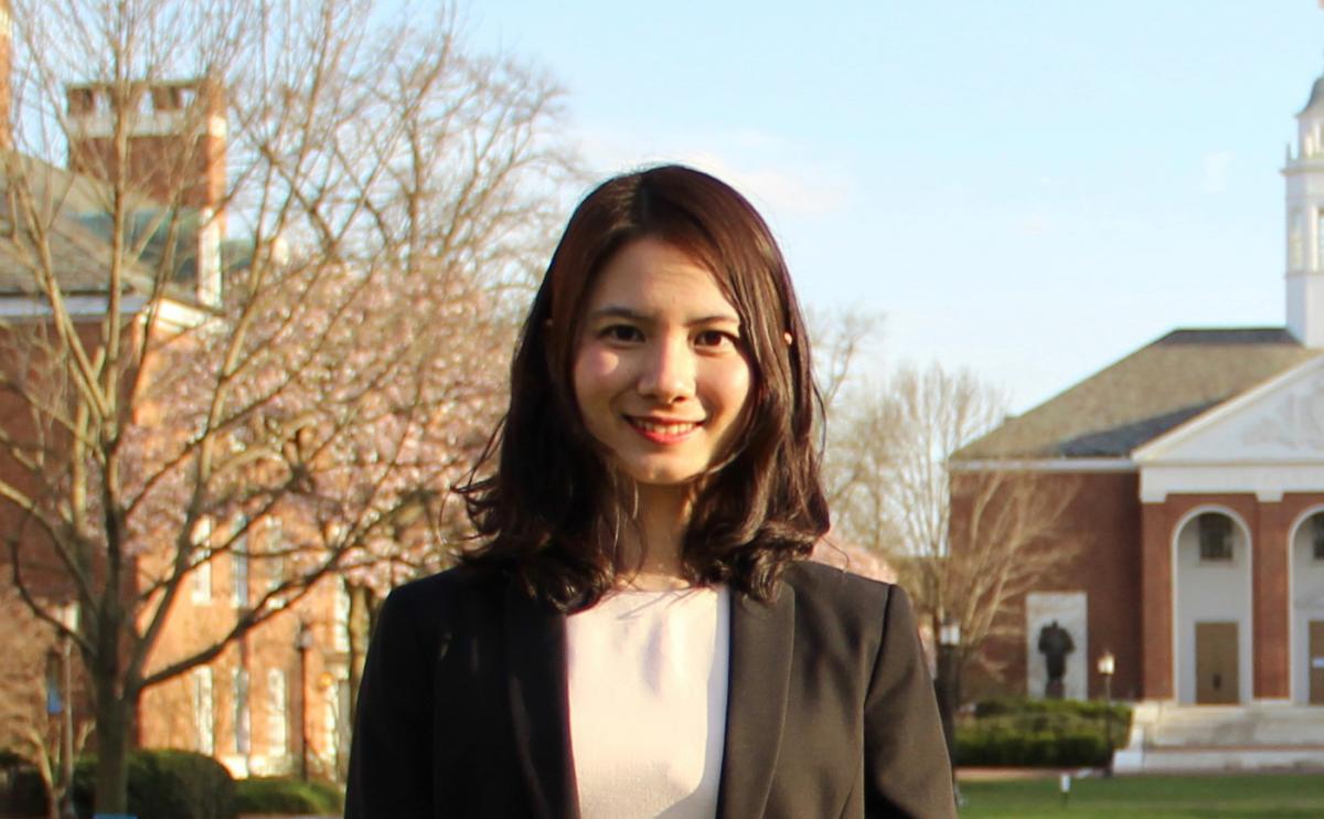 Wenpin Hou standing in front of brick buildings