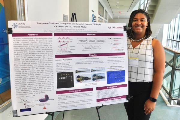 Tatyana Dunn stands beside her research poster for GCB