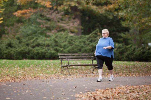 woman walking in paved path in park