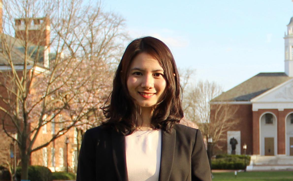 Wenpin Hou standing in front of brick buildings