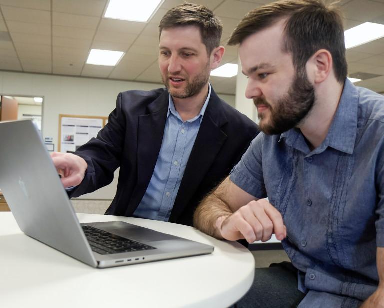 Matthew Engelhard and Elliot Hill looking at laptop computer