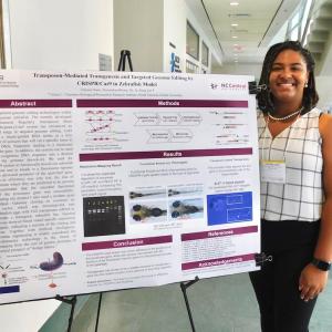 Tatyana Dunn stands beside her research poster for GCB