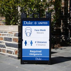 sign at duke that says Duke United; face masks, six feet distance required