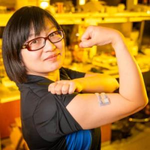 Person holding their sleeve up and flexing bicep to show off sensor